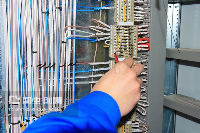 電工的手對電器柜的端子進行接線。The electrician`s hand carries out wiring to the terminals of the electrical cabinet.